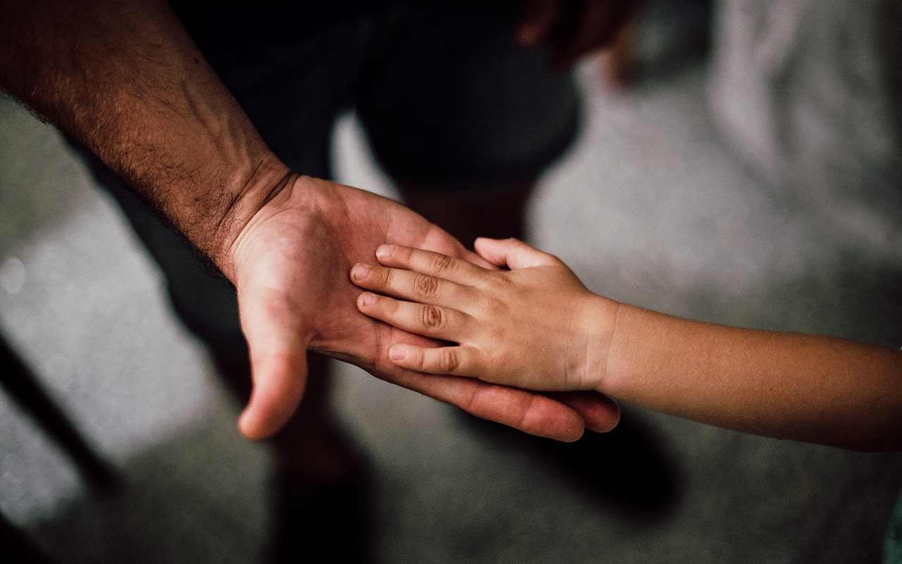 Un padre e un figlio che si tengono la mano