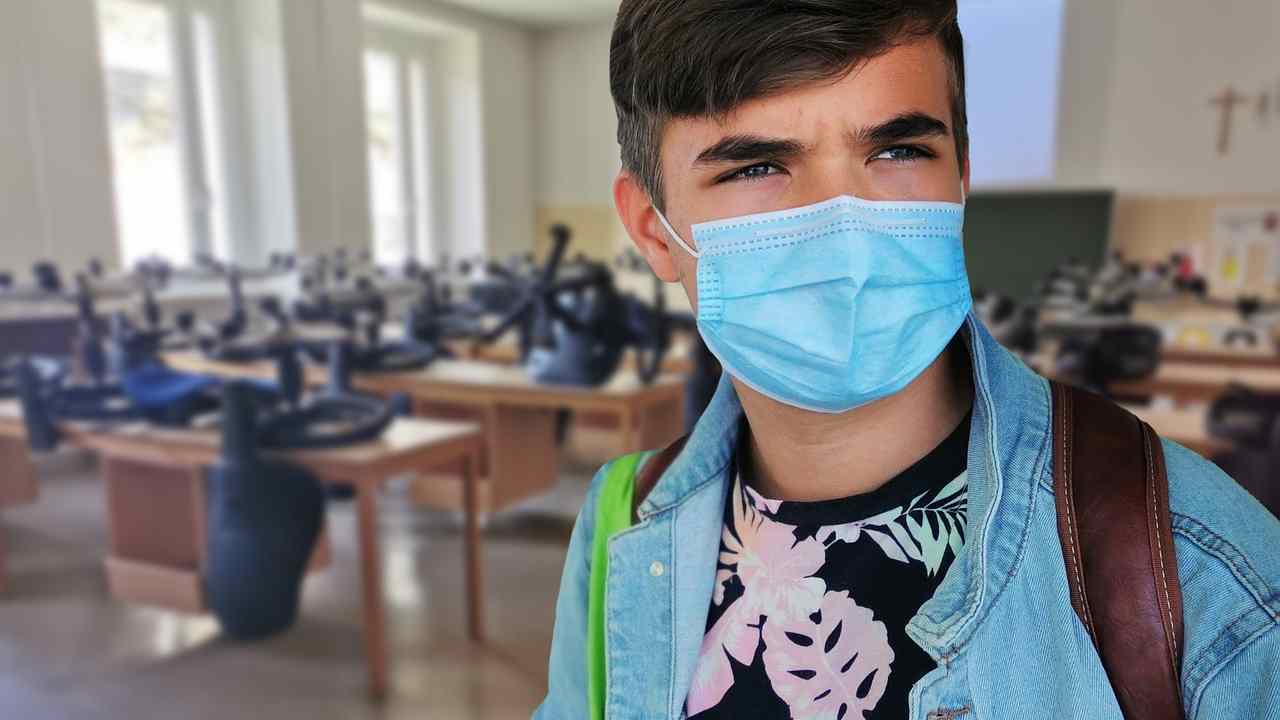 Un bambino indossa una mascherina a scuola, in un'aula vuota