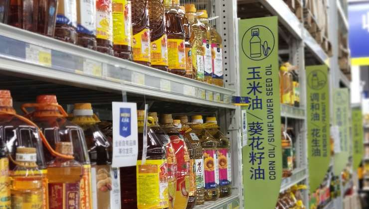 Scaffale di un supermercato pieno di bottiglie di olio di semi