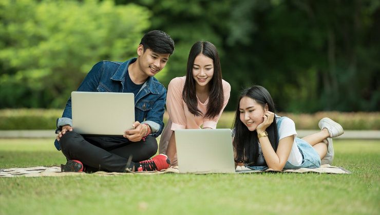 Cina, tre giovani navigano su internet con i loro computer