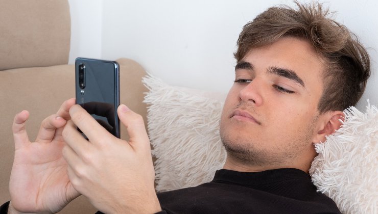 Teenager annoiato mentre consulta il suo smartphone