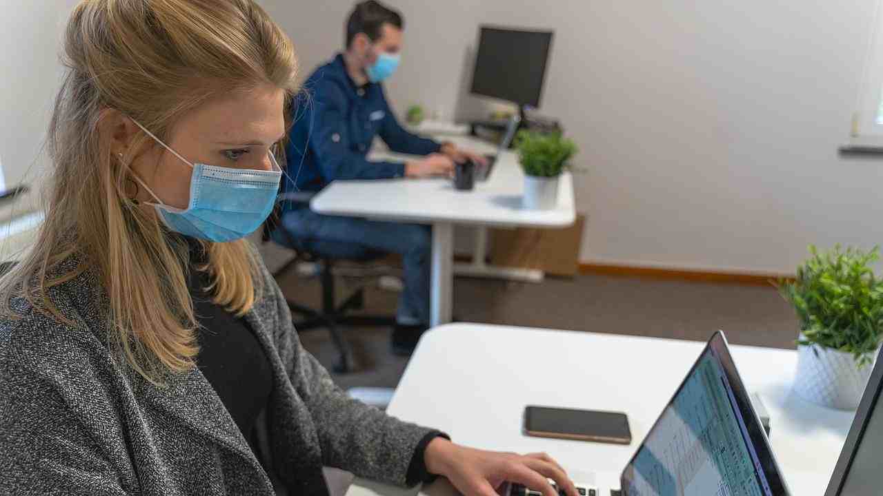 Una donna indossa la mascherina al lavoro
