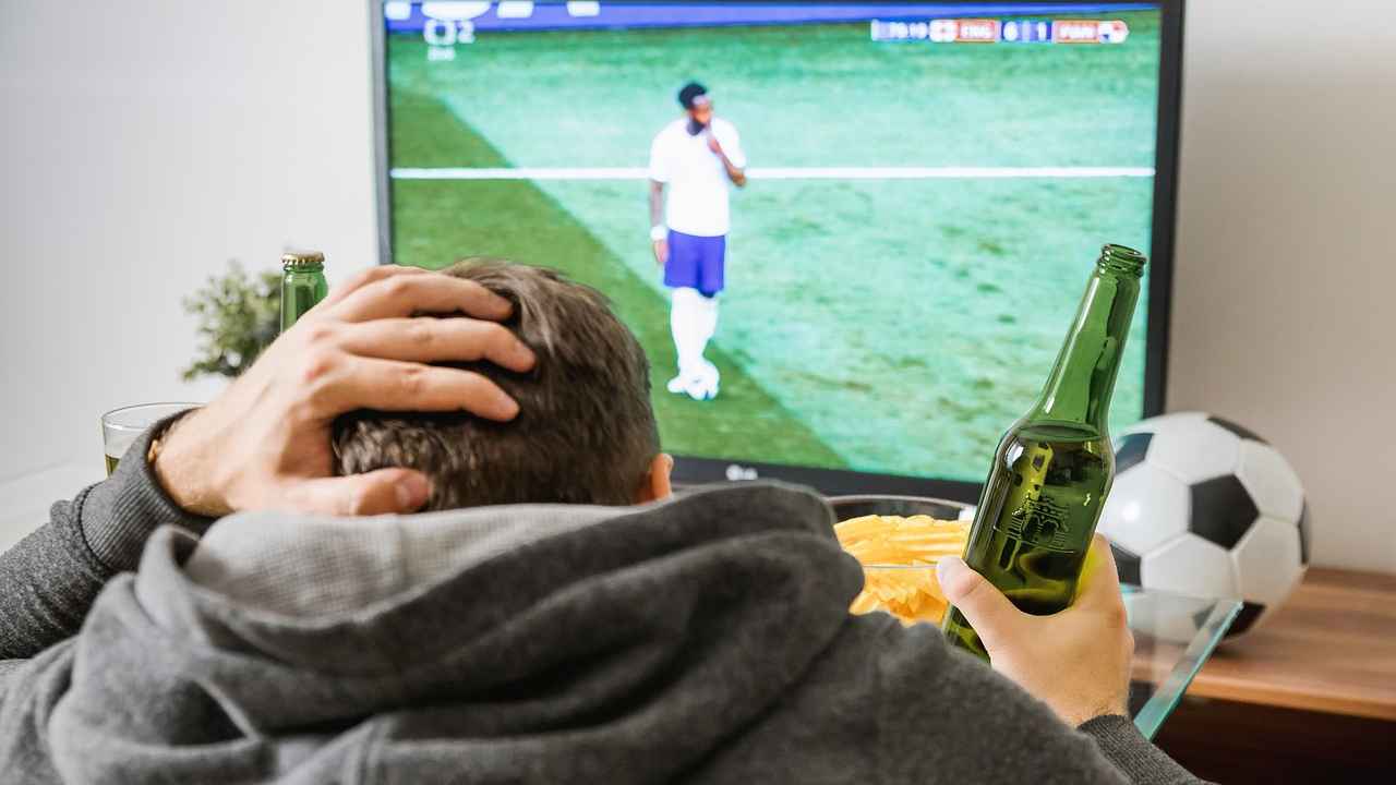 Giovane tifoso guarda partita di calcio in tv