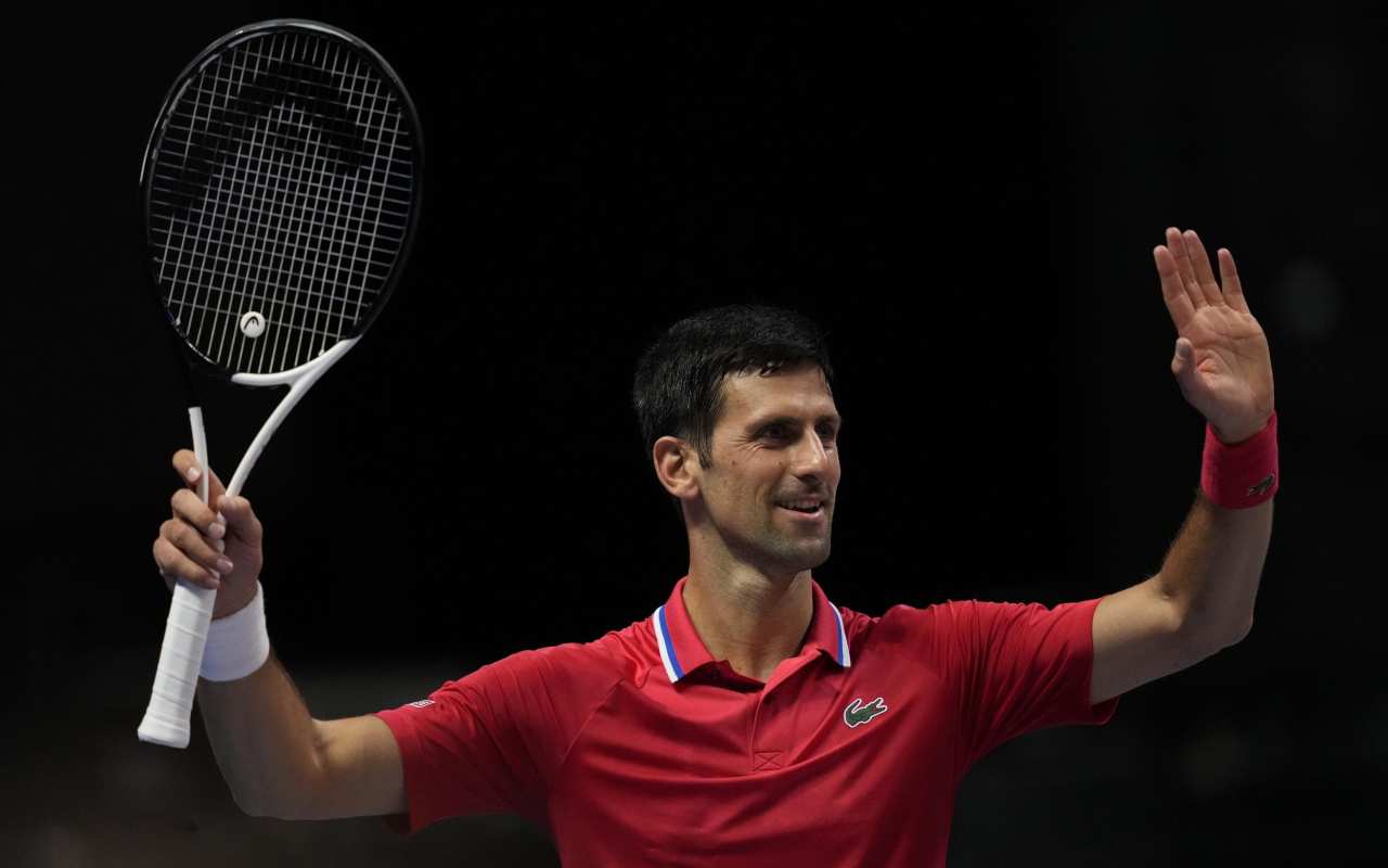 Djokovic sorride con la racchetta in mano 