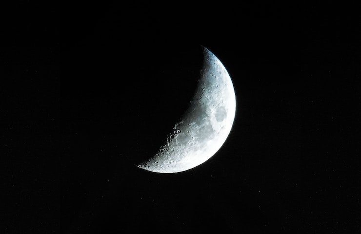Spicchio di luna illuminata, nel cielo buio della notte