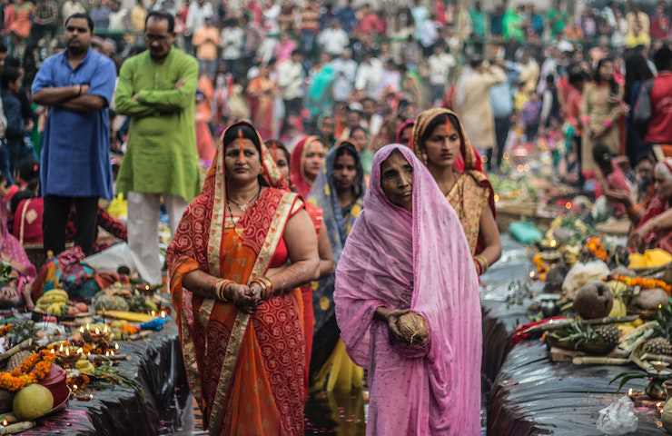 Donne e uomini indiani con vestiti tipici del proprio Paese, camminano per strada
