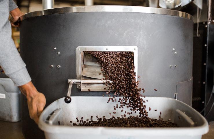 Macchinario per la macina dei chicchi di caffè al lavoro