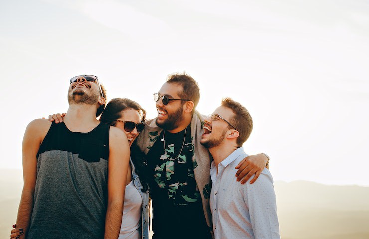 Gruppo di amici sorridenti, stretti in un abbraccio