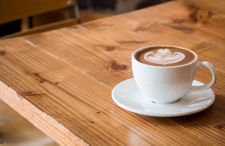 Tazzina di caffè appoggiata su un tavolo in legno