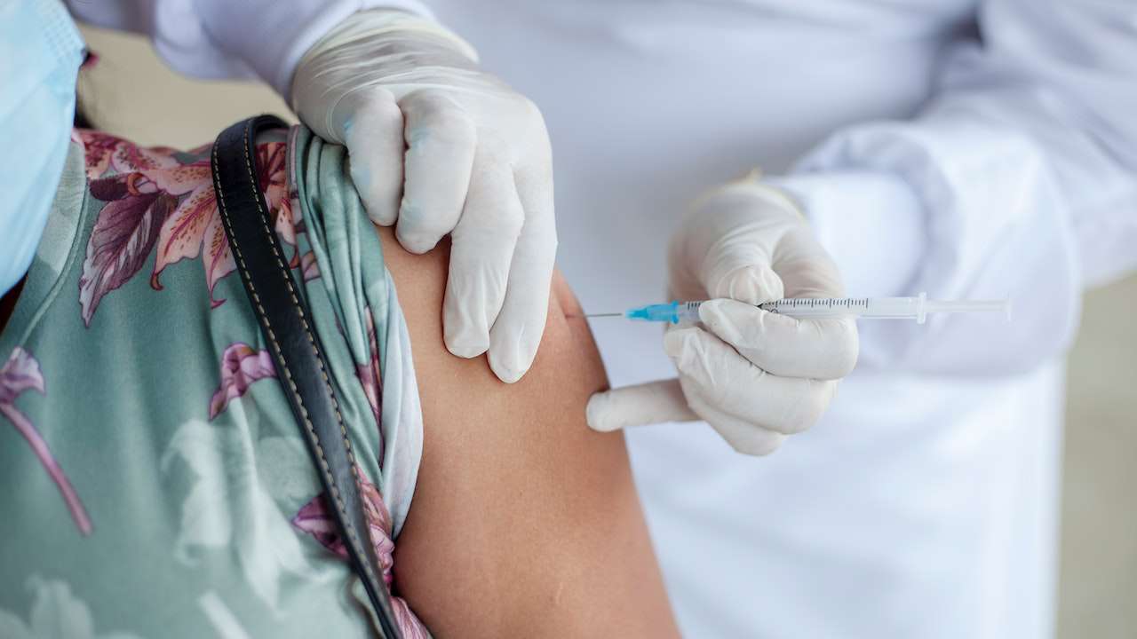 Dottore inietta vaccino antinfluenzale nel braccio di un paziente