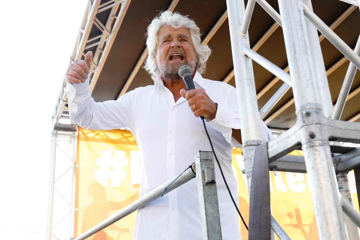 Beppe Grillo con un microfono in mano durante la manifestazione del Movimento 5 Stelle