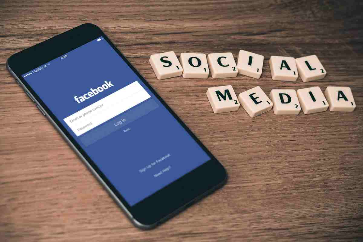 Cellulare con Facebook aperto e scritta social media