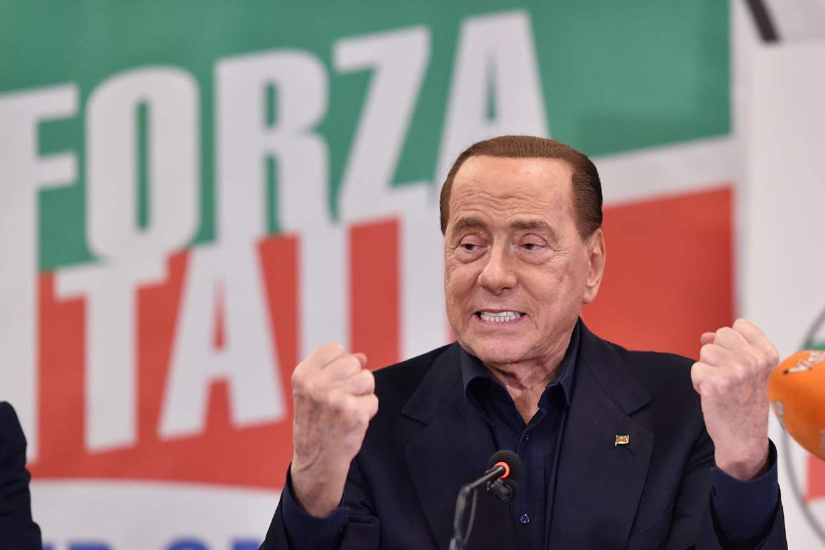 La bandiera di Forza Italia svetta dietro a Silvio Berlusconi