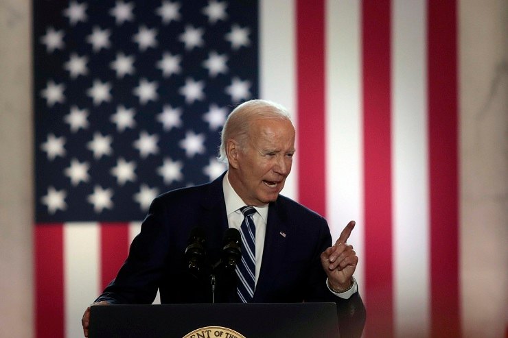 Il presidente Biden con dietro la bandiera a stelle e strisce