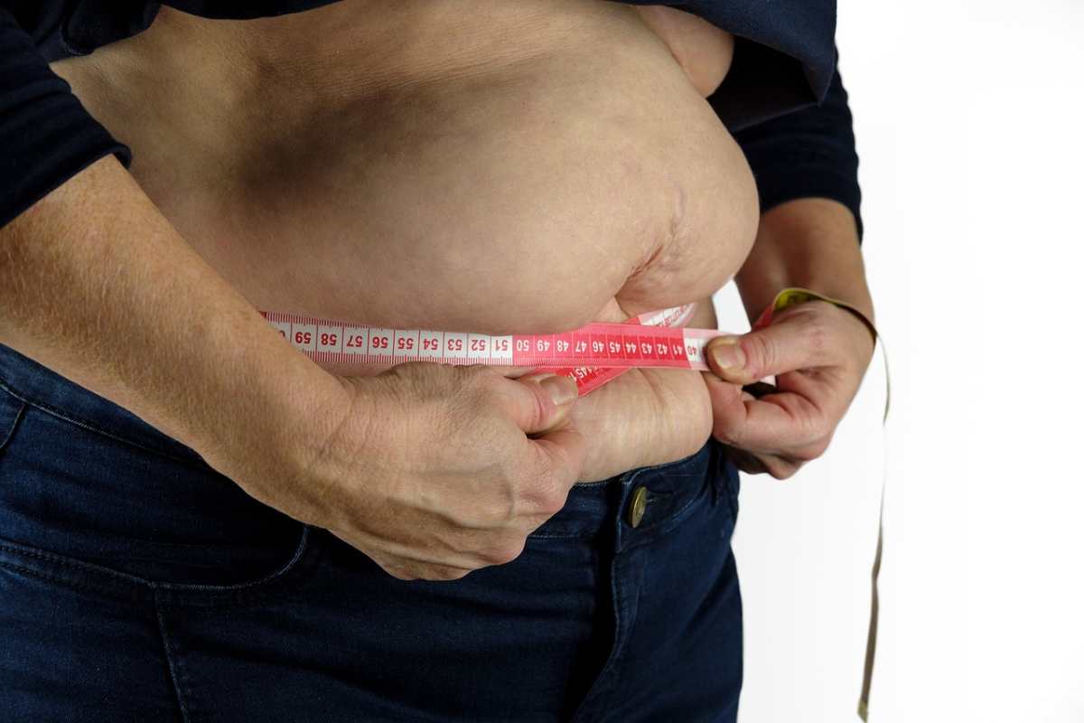 Cresce il numero degli italiani in sovrappeso. Nella foto: un uomo che si misura la circonferenza della vita