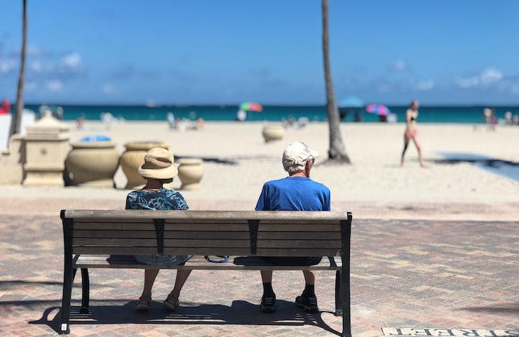 Anziani seduti su una panchina al mare d'estate