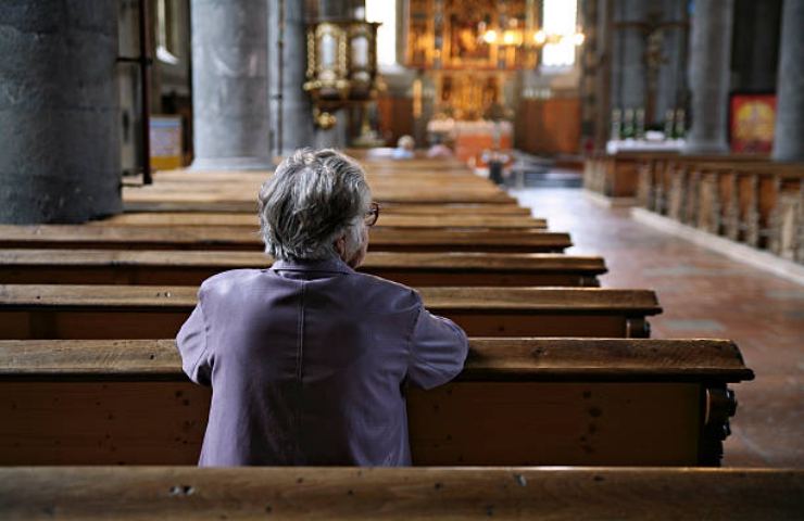 Donna cristiana prega in una chiesa