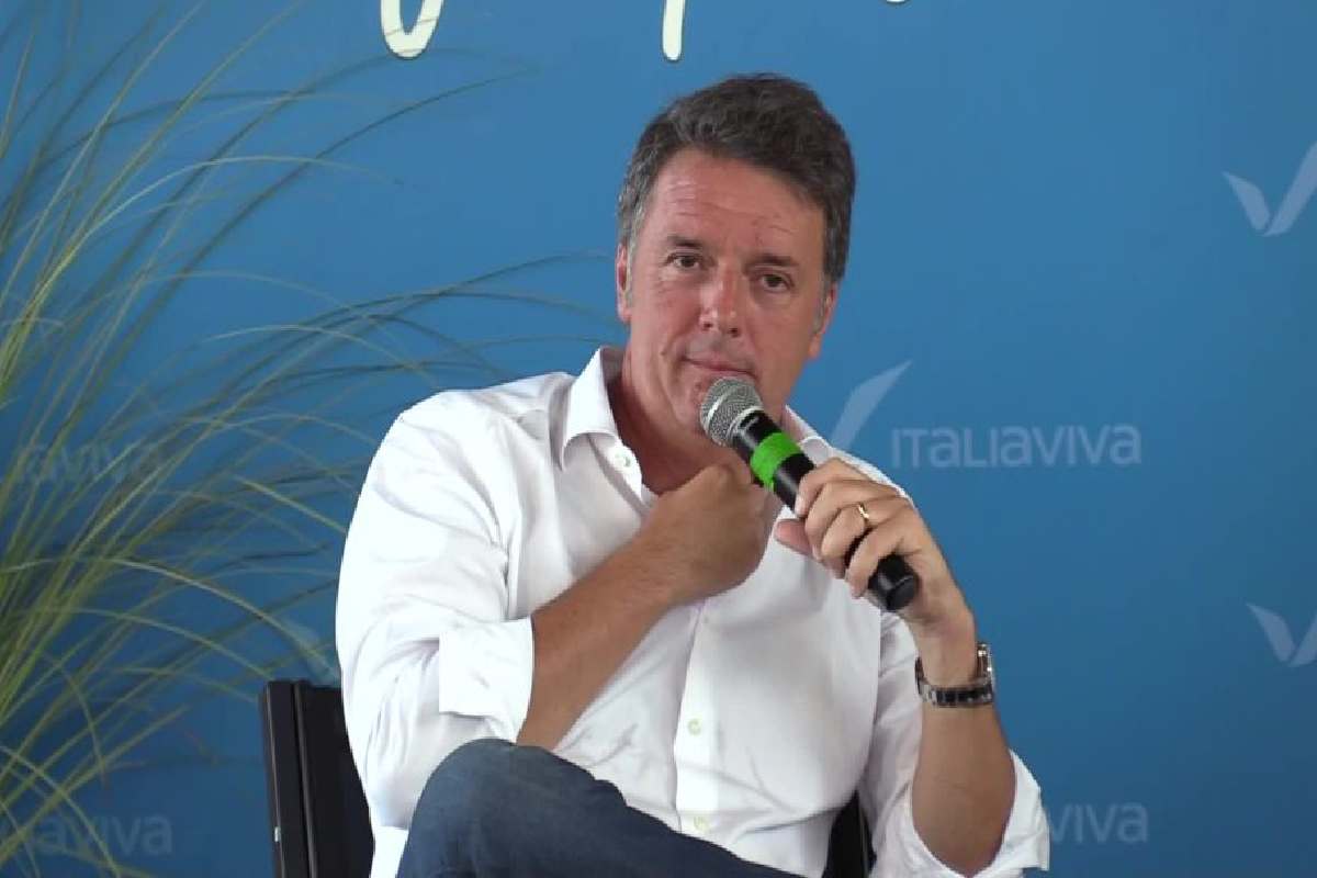 Matteo Renzi seduto con il microfono in mano