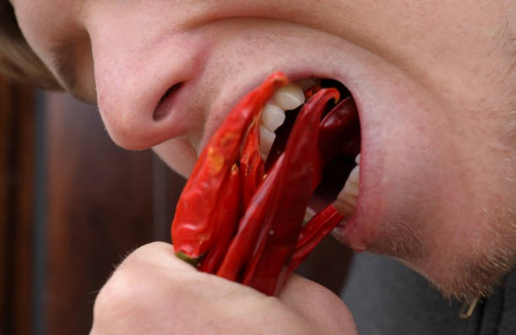 Ragazzo mangia dei peperoncini per una sfida social