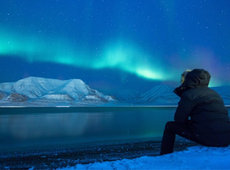Un uomo osserva l'aurora boreale