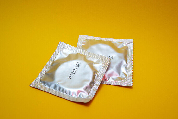 Due preservativi su sfondo giallo 