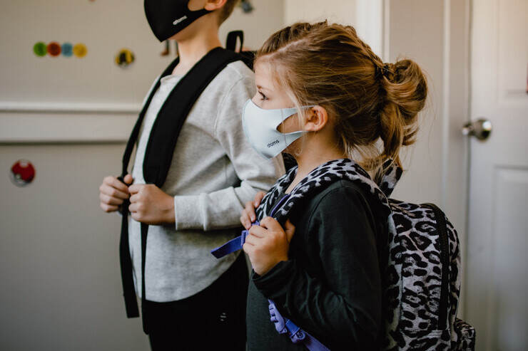 Due giovani studenti a scuola con le mascherine 