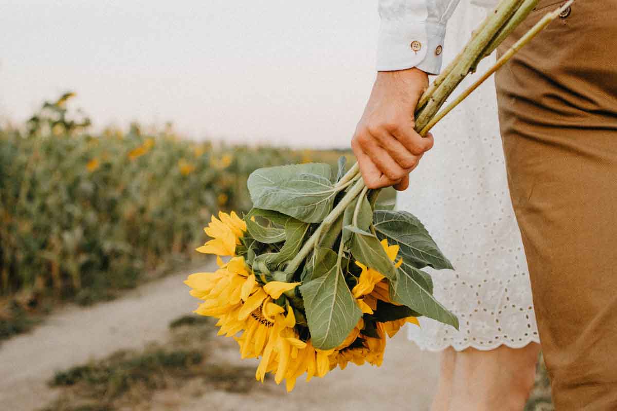 una coppia e un mazzo di girasoli