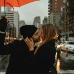 coppia si bacia sotto la pioggia
