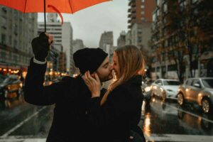 coppia si bacia sotto la pioggia