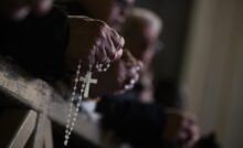 Cresce l'interesse per le app di preghiera: boom di ricerche su Google per "rosario online". Nella foto, fedeli che pregano con in mano un rosario