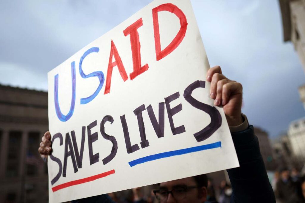 Un cartellone retto da un manifestante contrario allo smantellamento dell'USAID